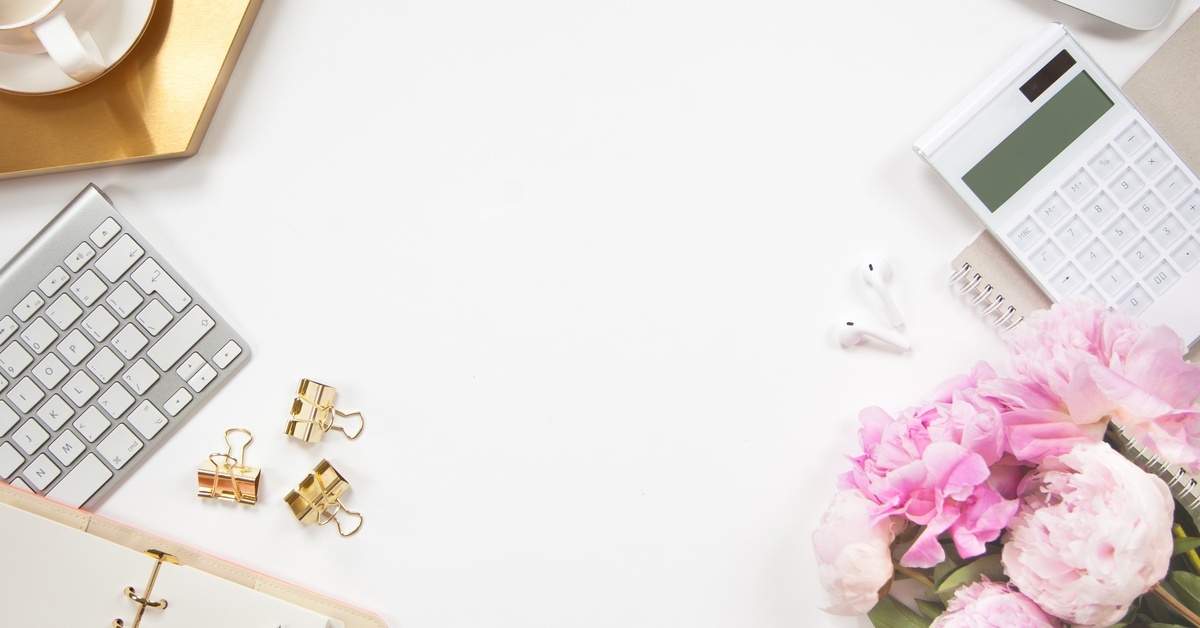 A top-down view of an office desk strewn with work accessories, such as a keyboard, calculator, and coffee cup with a coaster.